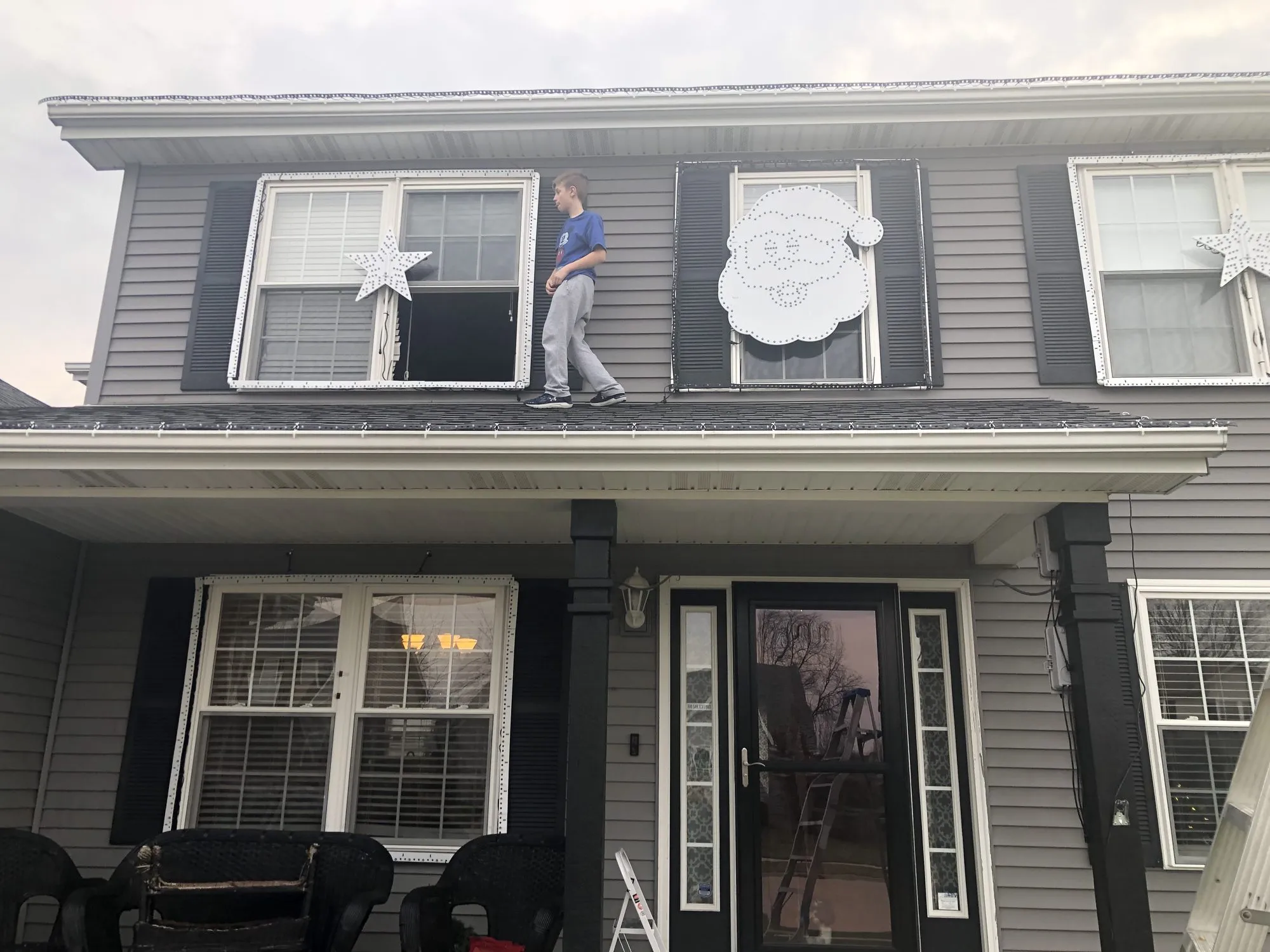 Max hangs Santa on the old house, 2019